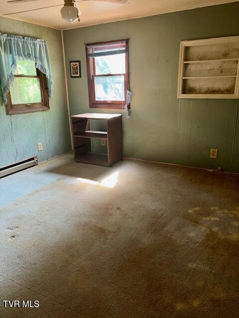 11616 Alfred Cox Rd, Pound, VA 24279 - unfurnished living room featuring carpet floors and a baseboard heating unit