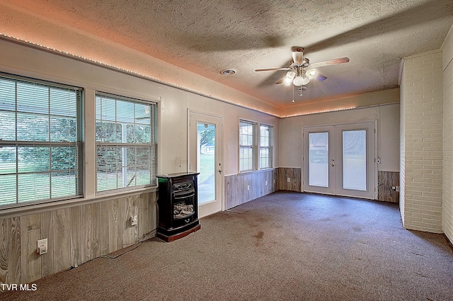 512 Old Airport Rd, Bristol, VA 24201 - unfurnished living room with french doors, carpet, a textured ceiling, wooden walls, and ceiling fan