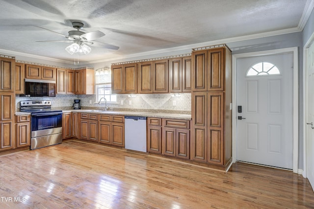 118 Hilbert Cir, Jonesborough, TN 37659 - kitchen featuring appliances with stainless steel finishes, brown cabinets, light wood-style flooring, a ceiling fan, and crown molding