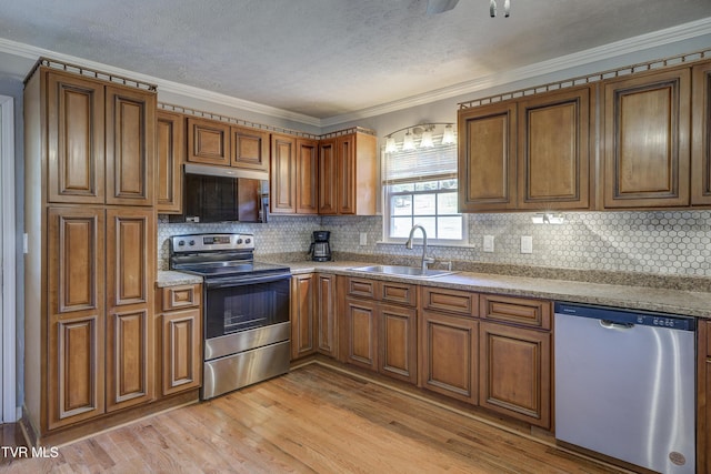 118 Hilbert Cir, Jonesborough, TN 37659 - kitchen featuring stainless steel appliances, crown molding, brown cabinets, light wood-style flooring, and tasteful backsplash