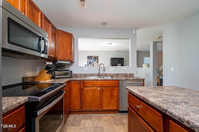 395 Kings Rd, Piney Flats, TN 37686 - kitchen with stainless steel appliances and brown cabinetry