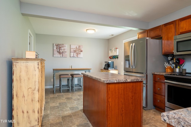 395 Kings Rd, Piney Flats, TN 37686 - kitchen with stainless steel appliances, a kitchen island, and brown cabinetry