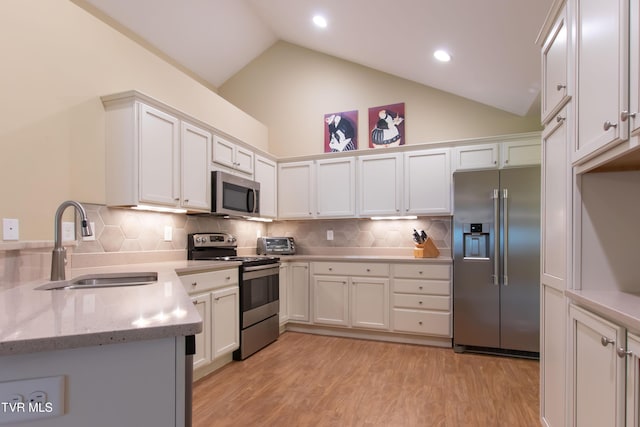 1551 Hatterdale Farm Rd Unit 1551, Blountville, TN 37617 - kitchen featuring appliances with stainless steel finishes, white cabinets, light wood-type flooring, tasteful backsplash, and light stone counters