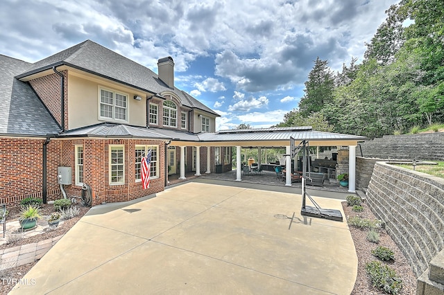 287 Pactolus Rd, Kingsport, TN 37663 - rear view of house featuring a chimney, brick siding, a patio, stucco siding, and a standing seam roof