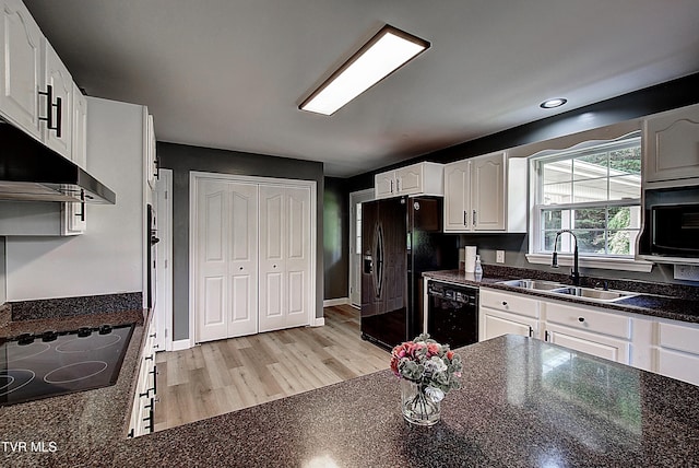 102 Spring Hill Dr, Unicoi, TN 37692 - kitchen featuring black appliances, white cabinets, under cabinet range hood, light wood-style floors, and dark stone counters