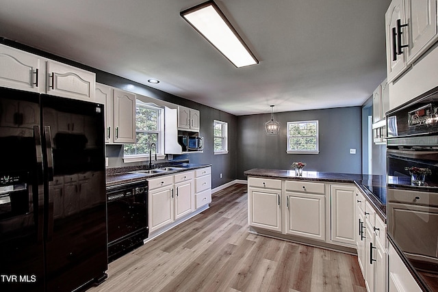 102 Spring Hill Dr, Unicoi, TN 37692 - kitchen featuring black appliances, a peninsula, dark countertops, white cabinetry, and light wood-style floors