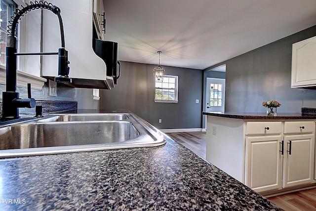 102 Spring Hill Dr, Unicoi, TN 37692 - kitchen with white cabinetry, a wood stove, light wood-style flooring, and pendant lighting