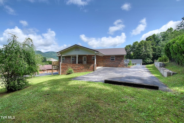 102 Spring Hill Dr, Unicoi, TN 37692 - back of property featuring a lawn, a metal roof, a mountain view, and brick siding