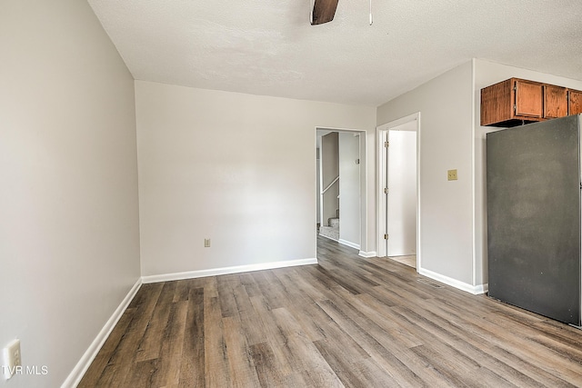 103 Northwinds Dr, Bristol, VA 24201 - empty room featuring wood finished floors, ceiling fan, stairway, and a textured ceiling
