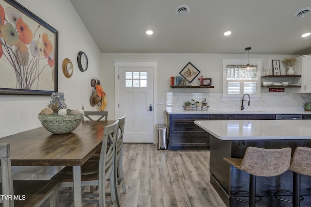 457 W St, Greeneville, TN 37745 - kitchen with open shelves, light countertops, light wood-style floors, a breakfast bar area, and tasteful backsplash