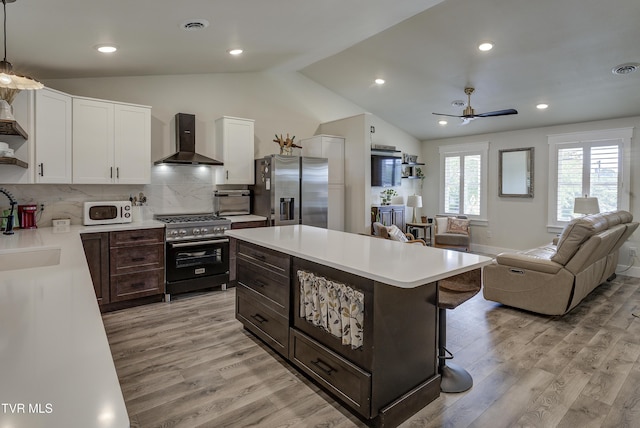 457 W St, Greeneville, TN 37745 - kitchen with wall chimney exhaust hood, stainless steel appliances, open shelves, open floor plan, and light countertops