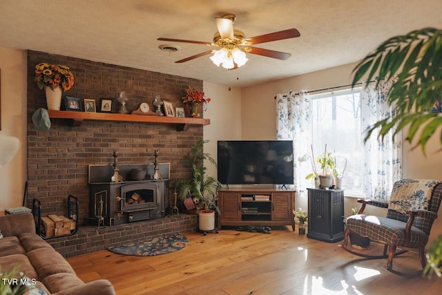 3521 James Phillips Way, Sevierville, TN 37876 - living area with a wood stove, wood finished floors, a ceiling fan, and a textured ceiling