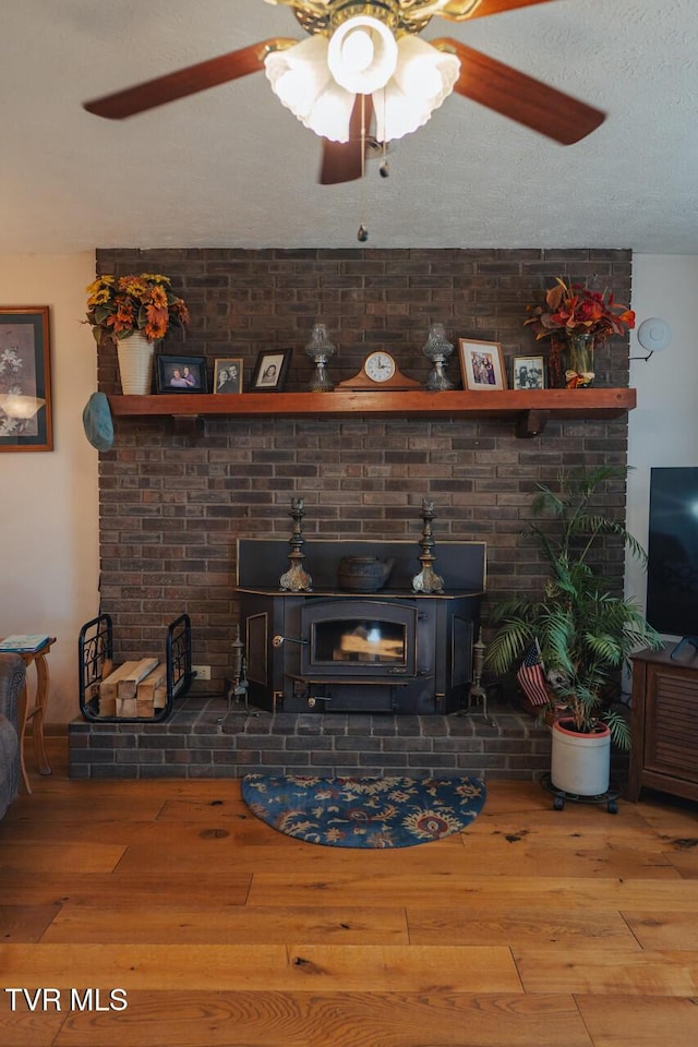 3521 James Phillips Way, Sevierville, TN 37876 - living room featuring ceiling fan, wood finished floors, a wood stove, and a textured ceiling