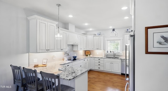 313 Treadway Trl, Jonesborough, TN 37659 - kitchen with a peninsula, black electric cooktop, white cabinetry, custom range hood, and recessed lighting