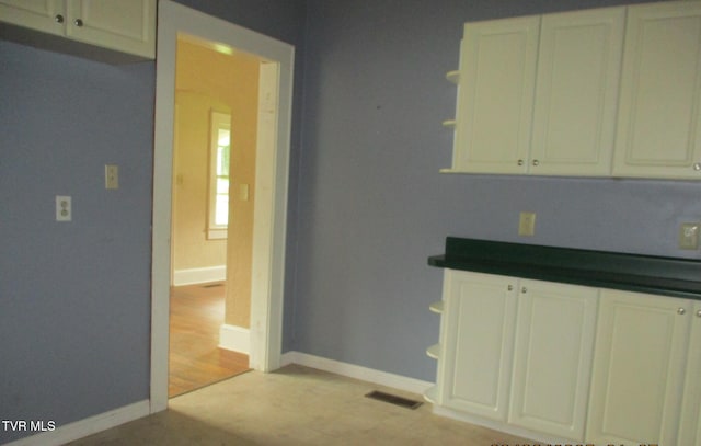 1234 Bristol Hwy, Elizabethton, TN 37643 - kitchen featuring open shelves, dark countertops, and white cabinetry