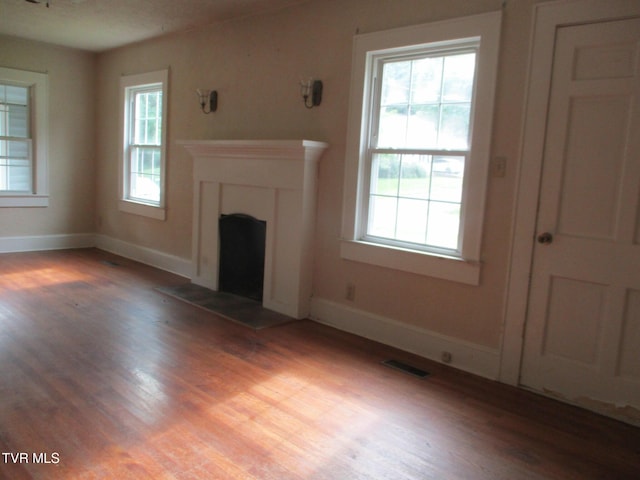 1234 Bristol Hwy, Elizabethton, TN 37643 - unfurnished living room featuring light wood-style flooring, a fireplace, and plenty of natural light