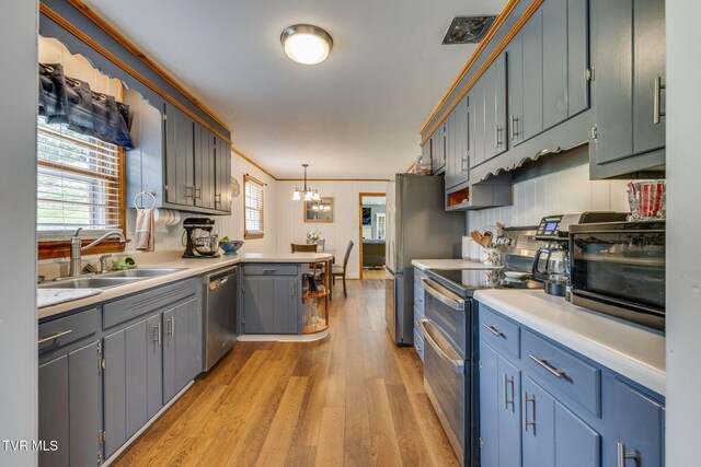309 Knob Hill Dr, Bristol, TN 37620 - kitchen featuring stainless steel appliances, a peninsula, light wood-type flooring, a chandelier, and light countertops
