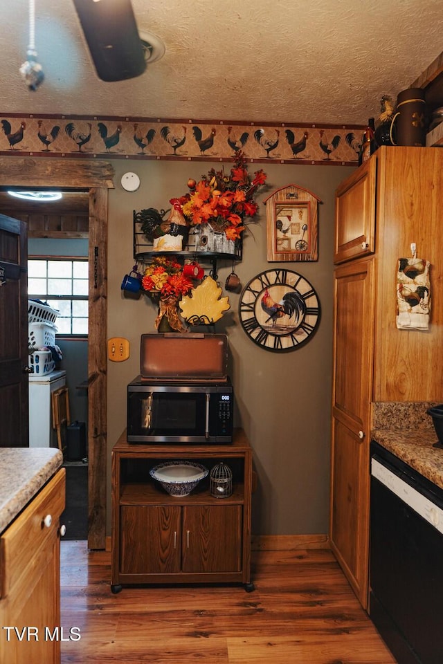 3504 James Phillips Way, Sevierville, TN 37876 - kitchen with stainless steel microwave, black dishwasher, wood finished floors, brown cabinets, and a textured ceiling