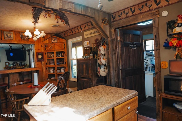 3504 James Phillips Way, Sevierville, TN 37876 - kitchen with a chandelier, a textured ceiling, black microwave, wood finished floors, and light countertops