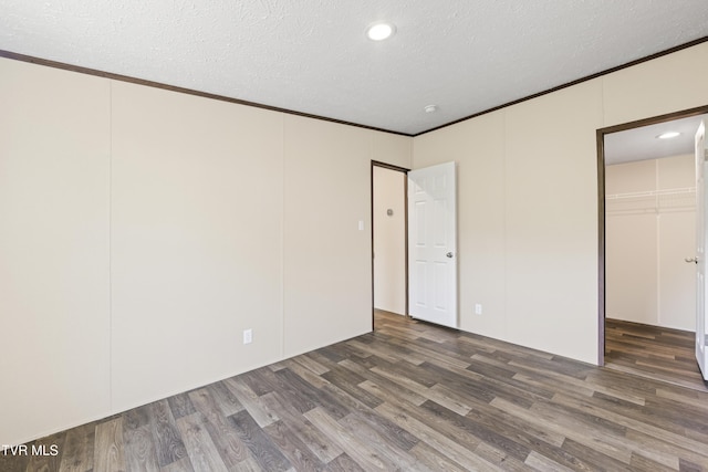 1826 Loop Rd, Lafollette, TN 37766 - unfurnished bedroom featuring wood finished floors, a textured ceiling, ornamental molding, a walk in closet, and a closet