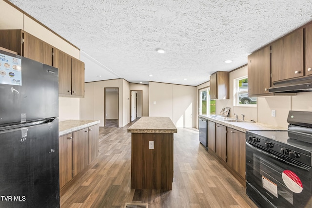 1826 Loop Rd, Lafollette, TN 37766 - kitchen with stainless steel appliances, under cabinet range hood, wood finished floors, a kitchen island, and light countertops