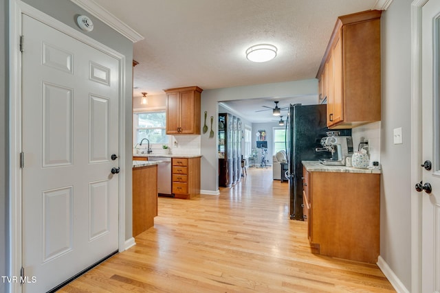 1933 Sand St, Kingsport, TN 37660 - kitchen with stainless steel dishwasher, brown cabinetry, ceiling fan, light wood-style floors, and crown molding