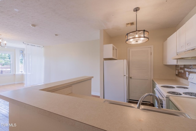 701 W Locust St Unit 34, Johnson City, TN 37604 - kitchen with white appliances, under cabinet range hood, a chandelier, light countertops, and white cabinetry