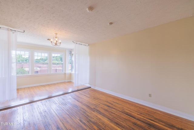 701 W Locust St Unit 34, Johnson City, TN 37604 - spare room with a chandelier, hardwood / wood-style floors, a smoke detector, and a textured ceiling