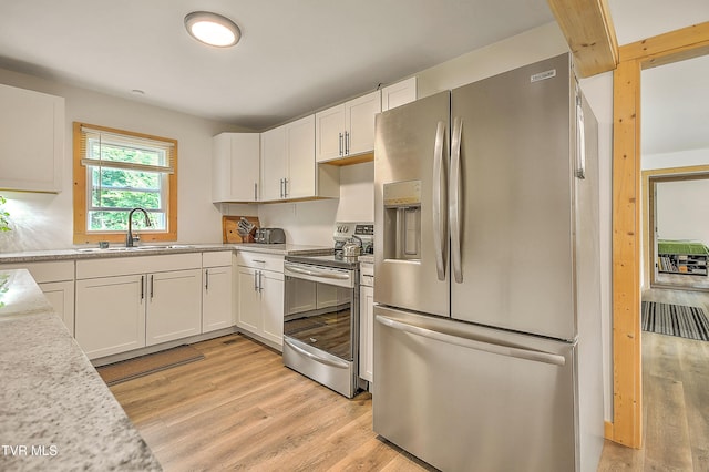 524 Boring Chapel Rd, Gray, TN 37615 - kitchen with appliances with stainless steel finishes, light wood-style flooring, light countertops, and white cabinetry