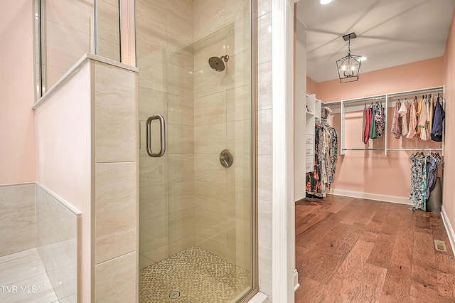 55 Farmstead Ln, Jonesborough, TN 37659 - full bathroom with a stall shower, a walk in closet, wood finished floors, and a chandelier