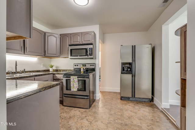 3025 Shipley St, Kingsport, TN 37664 - kitchen featuring appliances with stainless steel finishes, gray cabinets, and dark countertops