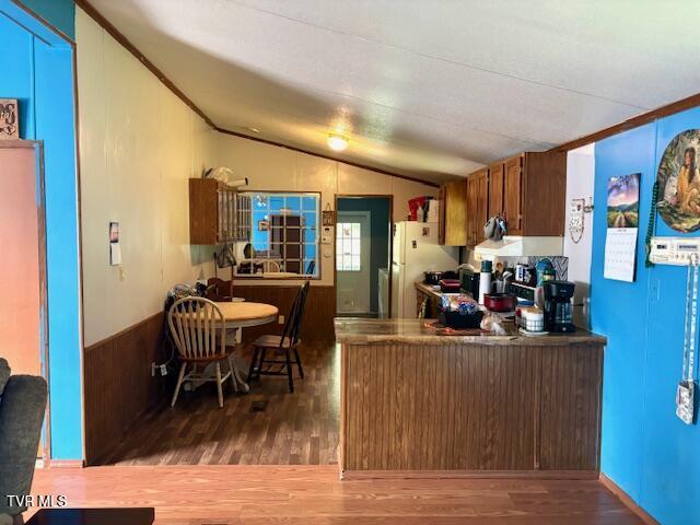 222 SW Azalea Dr, Wise, VA 24293 - kitchen with freestanding refrigerator, vaulted ceiling, wood finished floors, and a peninsula