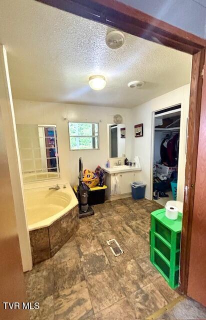222 SW Azalea Dr, Wise, VA 24293 - bathroom with a bath, a textured ceiling, vanity, and a spacious closet