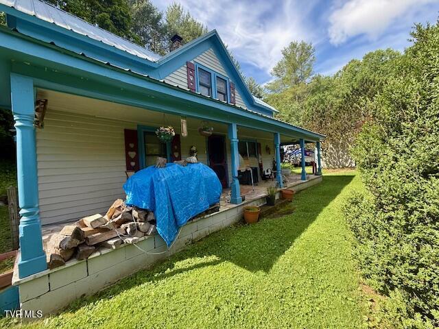 123 Mcmahan Gibbs Rd, Roan Mountain, TN 37687 - view of side of home featuring a porch, a yard, and a metal roof