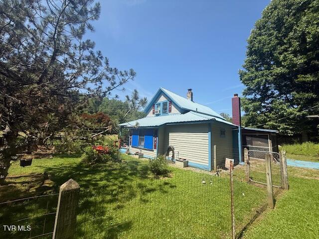 123 Mcmahan Gibbs Rd, Roan Mountain, TN 37687 - view of side of home featuring a chimney, a yard, and a metal roof
