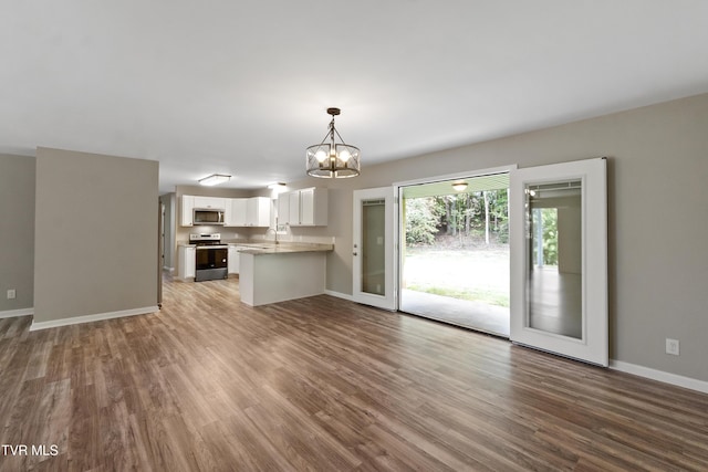 113 Paul Mathes Rd, Chuckey, TN 37641 - unfurnished living room with wood finished floors and a chandelier
