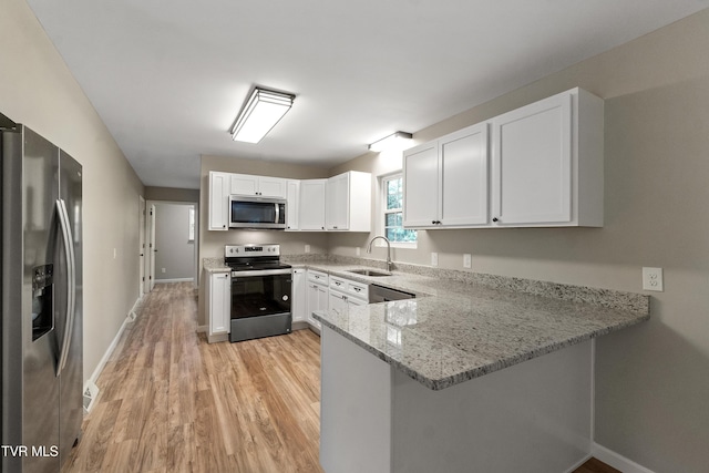 113 Paul Mathes Rd, Chuckey, TN 37641 - kitchen featuring stainless steel appliances, light wood-type flooring, light stone countertops, white cabinetry, and a peninsula
