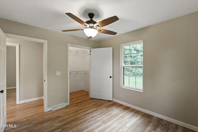 113 Paul Mathes Rd, Chuckey, TN 37641 - unfurnished bedroom with wood finished floors, a closet, a ceiling fan, and a spacious closet