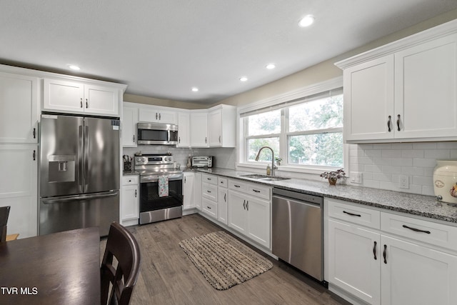 1908 Old Tusculum Rd, Greeneville, TN 37745 - kitchen featuring appliances with stainless steel finishes, white cabinetry, dark wood-type flooring, backsplash, and recessed lighting