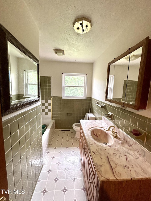 6361 Dr Thomas Walker Rd, Rose Hill, VA 24281 - bathroom featuring tile walls, a bath, vanity, wainscoting, and a textured ceiling