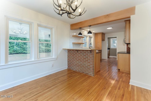 461 S Shady Ave, Damascus, VA 24236 - kitchen with a chandelier, a peninsula, a kitchen bar, light wood finished floors, and healthy amount of natural light