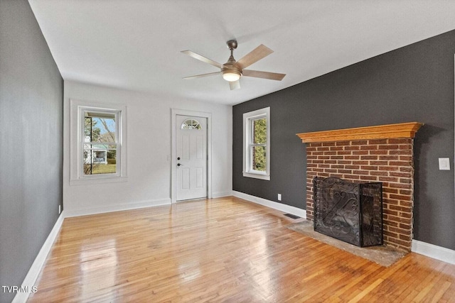 461 S Shady Ave, Damascus, VA 24236 - unfurnished living room featuring healthy amount of natural light, a ceiling fan, wood finished floors, and a fireplace