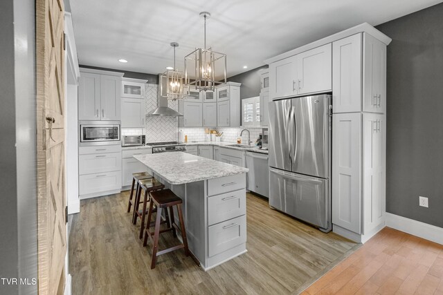 512 Shea Ct, Morristown, TN 37814 - kitchen featuring stainless steel appliances, wall chimney range hood, a chandelier, recessed lighting, and a breakfast bar area