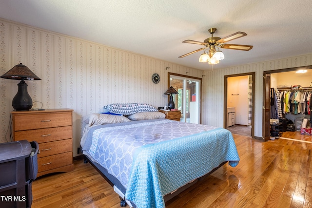 274 Hickam Orchard Rd, Kingsport, TN 37660 - bedroom with light wood finished floors, a walk in closet, a textured ceiling, a closet, and a ceiling fan