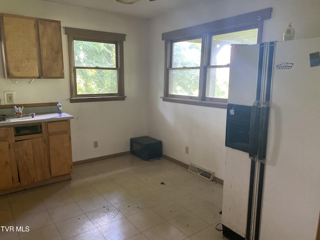 1959 Boones Creek Rd, Jonesborough, TN 37659 - kitchen with freestanding refrigerator, healthy amount of natural light, light countertops, and brown cabinetry