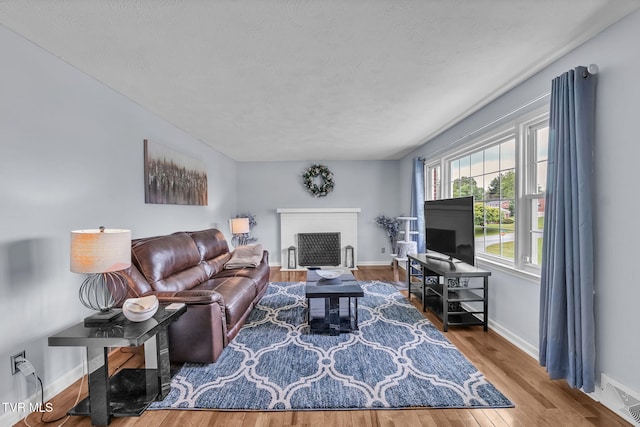 908 Middle Ave, Marion, VA 24354 - living room with wood finished floors, a fireplace with flush hearth, and a textured ceiling