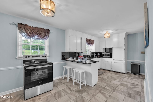 908 Middle Ave, Marion, VA 24354 - kitchen featuring appliances with stainless steel finishes, a peninsula, white cabinets, and dark countertops