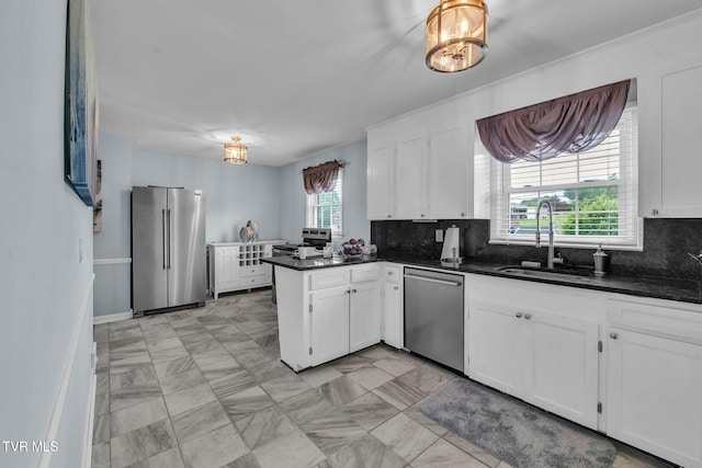 908 Middle Ave, Marion, VA 24354 - kitchen featuring appliances with stainless steel finishes, a peninsula, dark countertops, white cabinetry, and backsplash