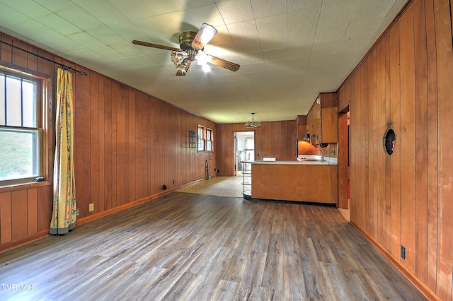 325 Cove Creek Rd, Roan Mountain, TN 37687 - kitchen featuring brown cabinetry, wood finished floors, wooden walls, ceiling fan, and light countertops