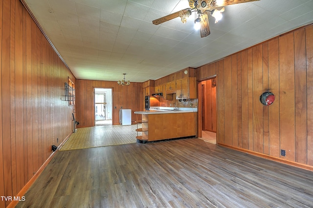 325 Cove Creek Rd, Roan Mountain, TN 37687 - kitchen featuring brown cabinetry, hardwood / wood-style flooring, wood walls, ceiling fan, and black oven